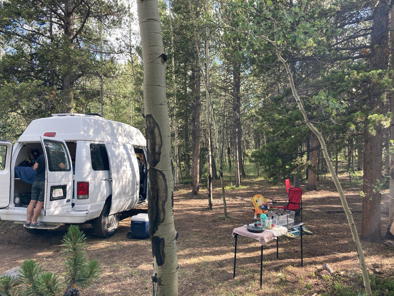  showing colorful patterned front seats and a custom bed area behind for travelers.|Spacious white high-top camper van — photo 3