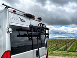 A Jayco rv rental at a vineyard, bike rack ready for scenic road trip exploration under cloudy skies.