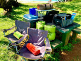RV rental adventure essentials: chairs, cooler, sleeping bags, & beach views for your next outdoor trip.