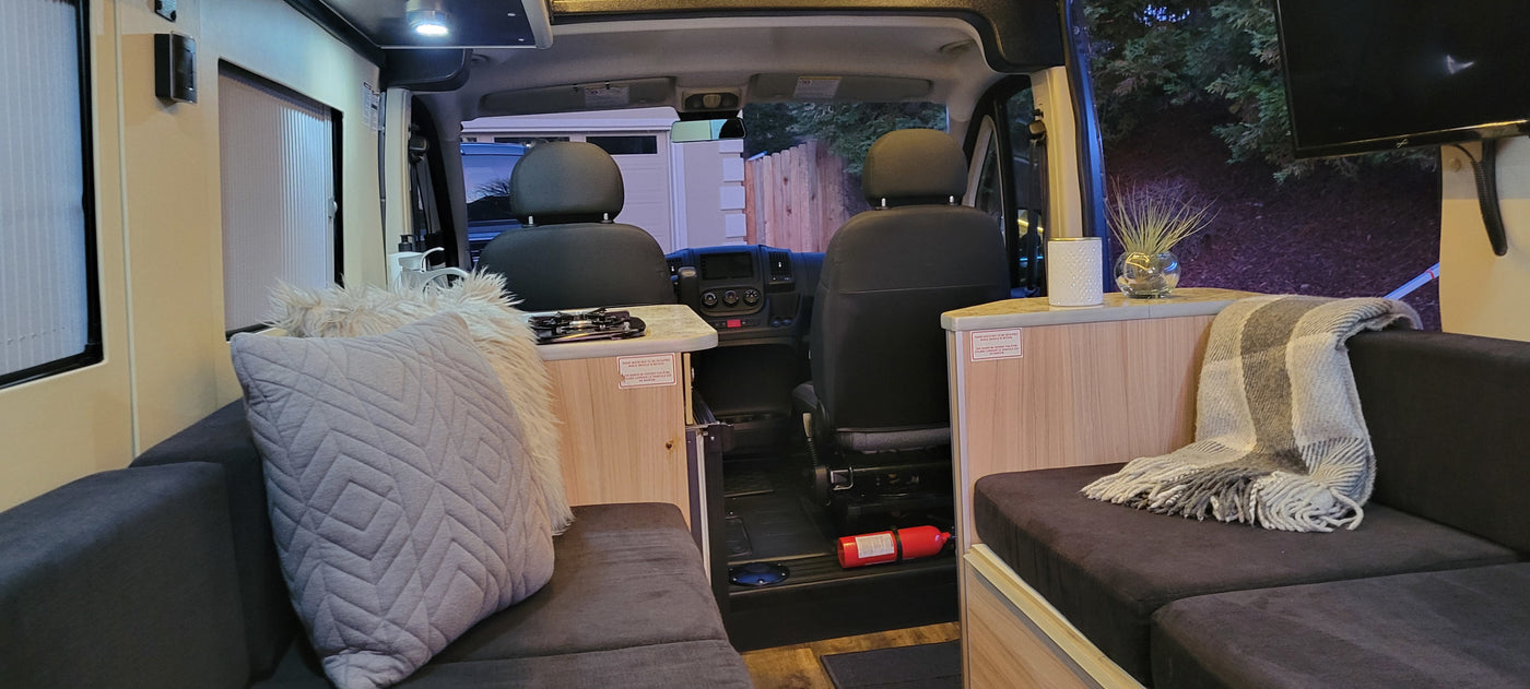 Experience a comfortable RV rental. This camper van interior features a compact kitchen, plush seating, and entertainment. — photo 5