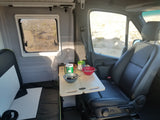 RV rental interior with breakfast on a portable table and a scenic desert view from the window.
