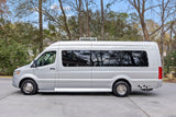 Side view of a silver Mercedes Sprinter RV rental camper van, parked outdoors.