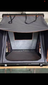 Open vehicle rooftop tent with a mattress and mesh window, ideal for RV rental camping adventures.