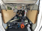 Spacious pop-up camper interior shows fold-up beds, kitchen, and gear storage for an RV rental adventure.