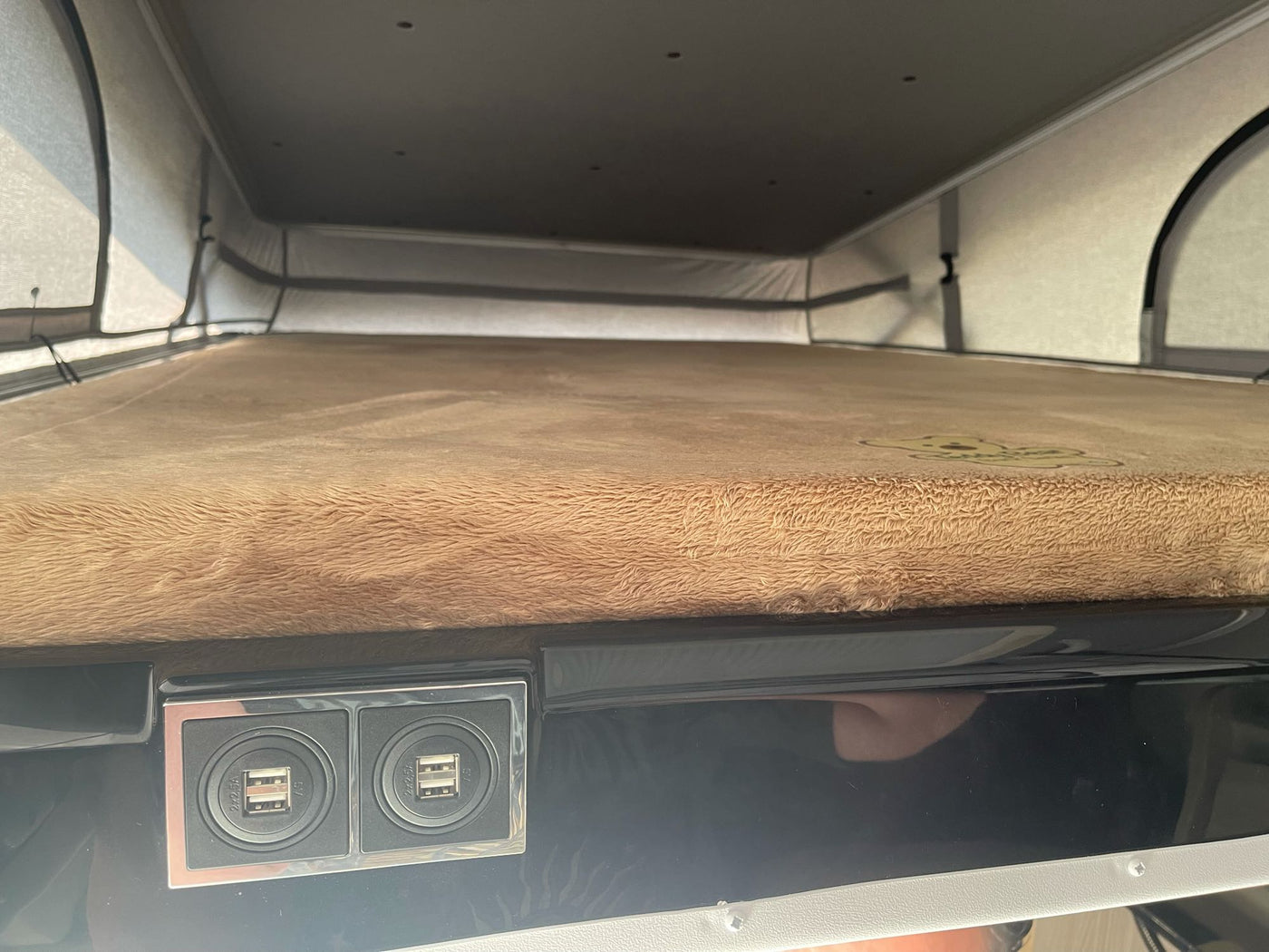 RV rental pop-top camper interior with a cozy bed and dual USB charging ports. Ideal sleeping space for your next adventure. — photo 10