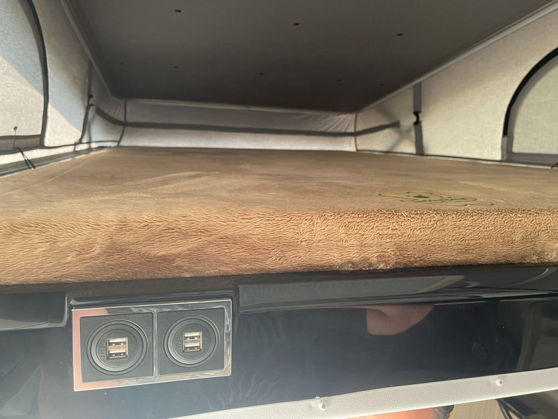 RV rental pop-top camper interior with a cozy bed and dual USB charging ports. Ideal sleeping space for your next adventure. — photo 10