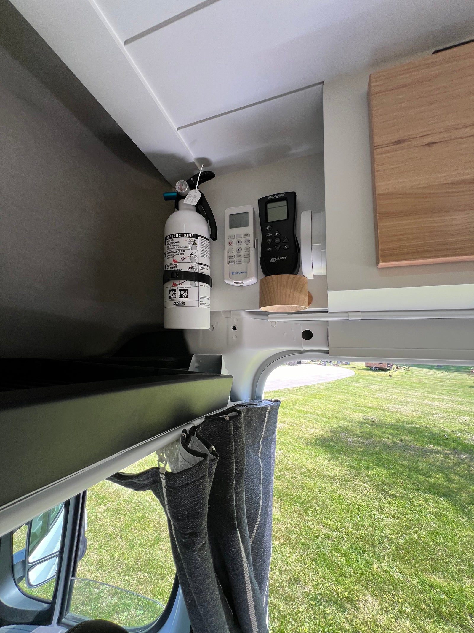 This RV rental's organized interior features a fire extinguisher, MaxxAir fan, and AC remotes for safety and comfort.