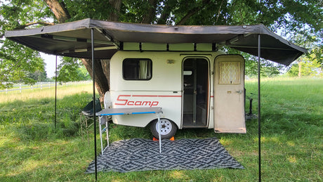 Scamp travel trailer RV rental, with a wide awning for shaded outdoor camping. A cozy tiny home on wheels.