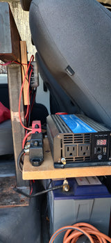 An inverter and battery setup provides off-grid power inside an RV rental or camper van.