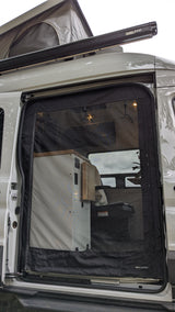 This RV rental pop-top camper van has an open side door, revealing a mesh screen, Fiamma awning, and custom interior.