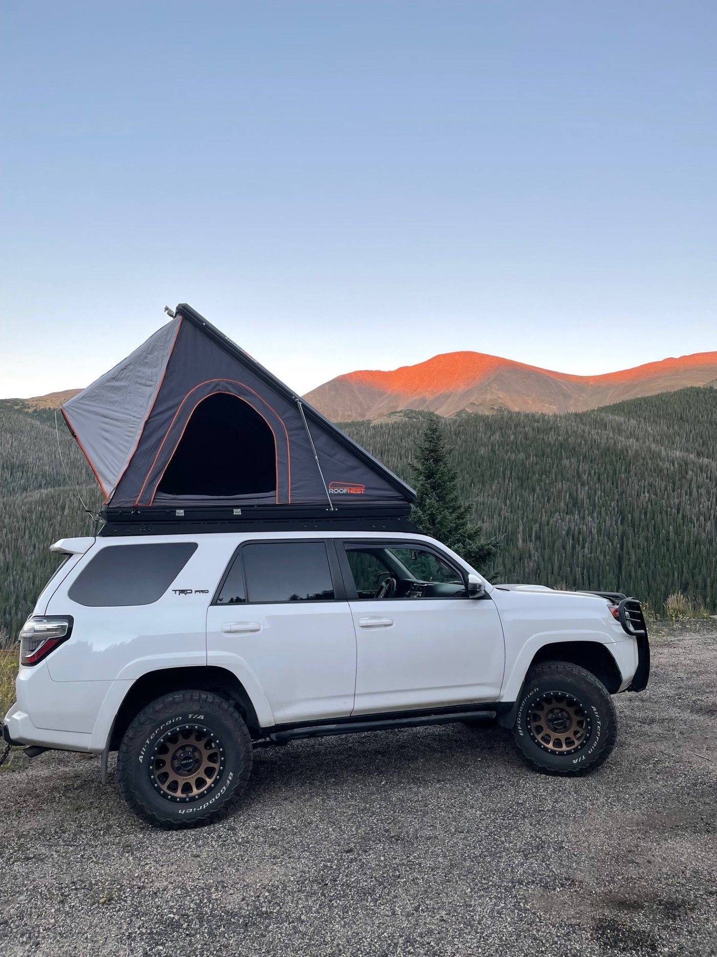 Perfect for your next RV rental adventure! A white 4Runner with a Roofnest rooftop tent overlooks vibrant mountains and forests. — photo 11