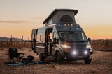 Experience desert sunsets in this pop-top rv rental! Van camping with chairs and a fire pit under a warm sky.