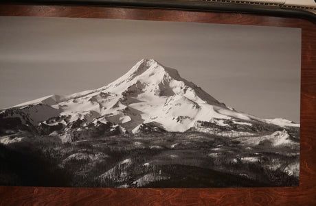A serene black and white print showcases a snow-capped mountain above dark forests, inspiring RV rental trips.