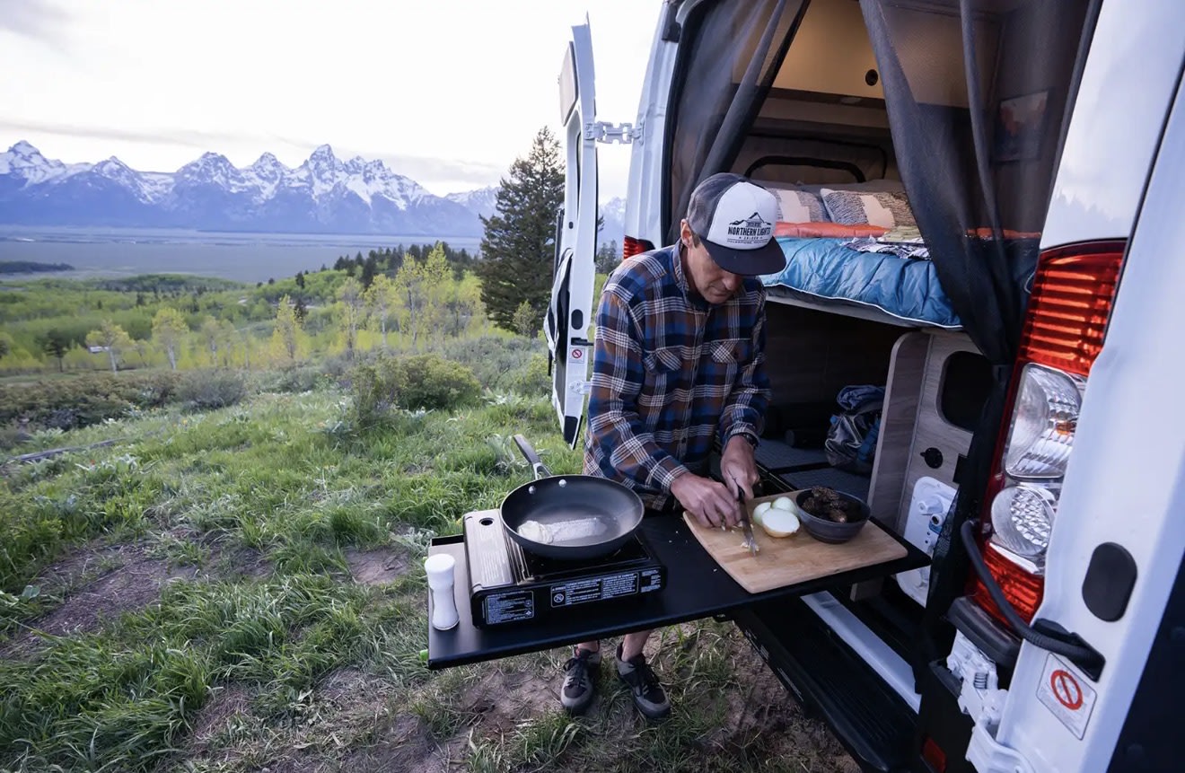  all overlooking a scenic mountain view.|RV rental interior: Cozy camper van with bed — photo 4