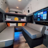 Inside an RV rental: plush seating, bunk beds, and a TV with streaming apps like Netflix and Hulu for your journey.
