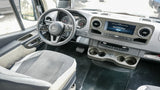 Spacious Mercedes-Benz RV rental interior with a modern dashboard, large screen, and comfortable driver's seat.