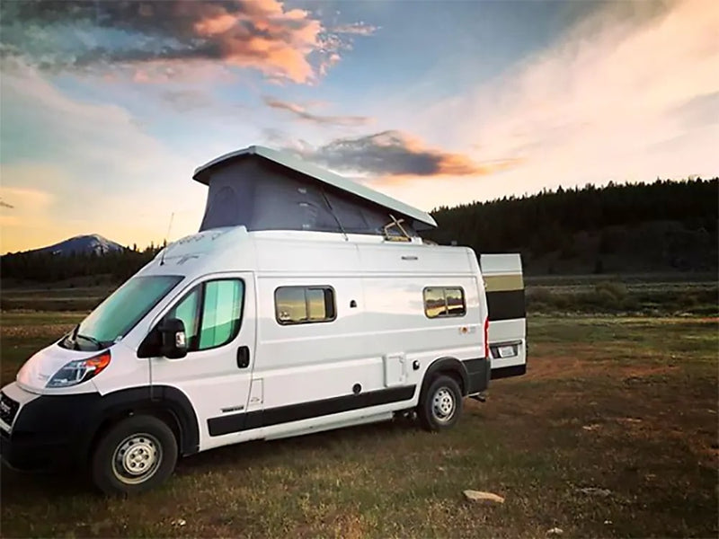 White pop-top RV rental in a scenic field — photo 1
