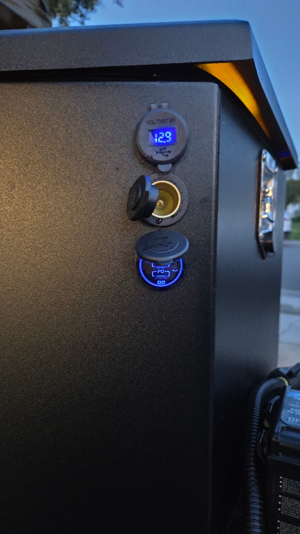 RV rental charging station: A power panel with a 12.9V voltmeter, 12V socket, and blue-lit USB PD charger. — photo 8