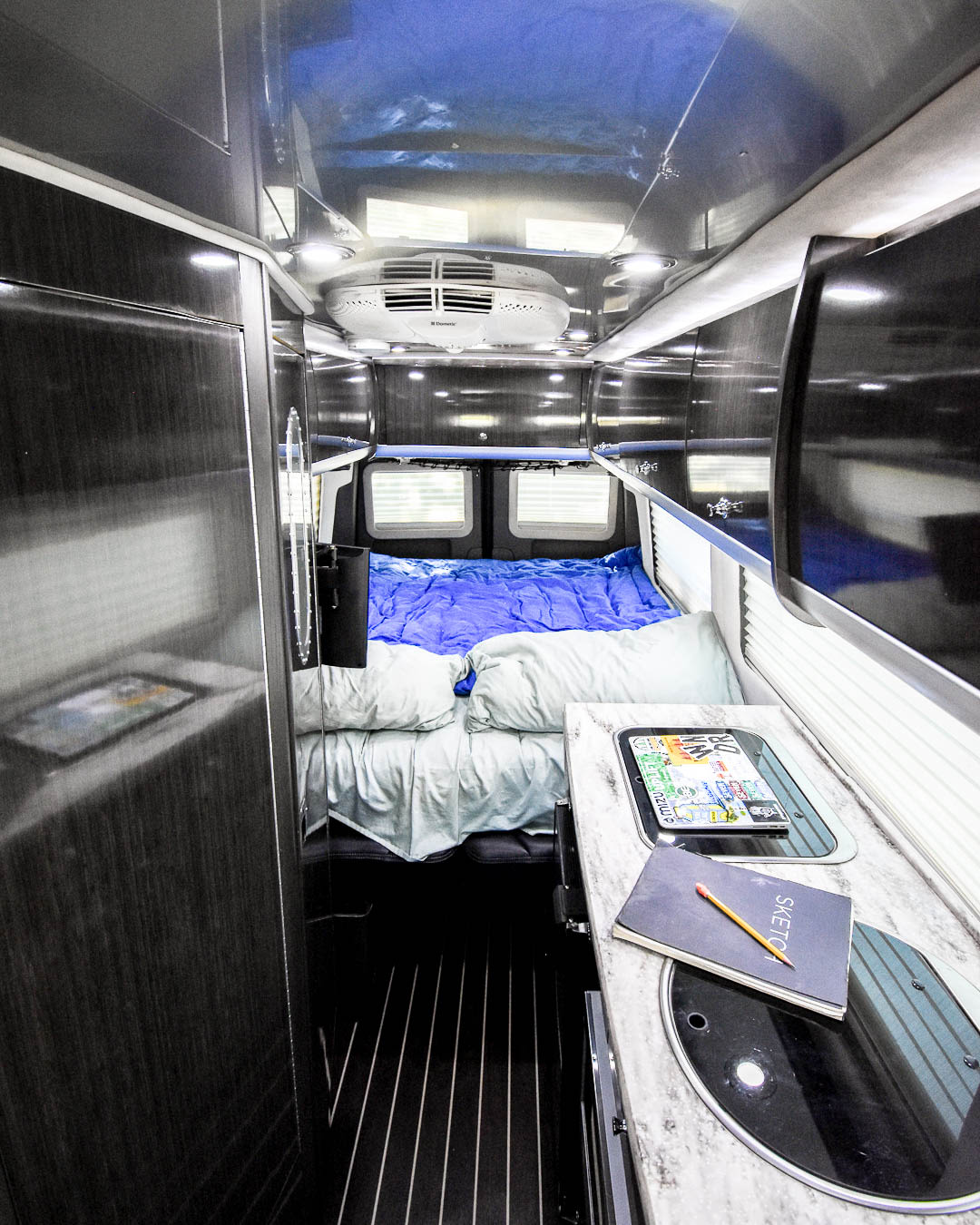  and stylish wood-look flooring.|View inside an RV rental: a narrow aisle leads to a bed — photo 5