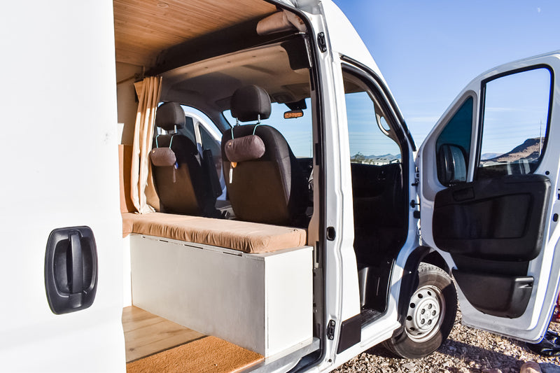 Inside this white RV rental camper van: front seats, custom bench, wood ceiling, and open doors revealing a mountain view. — photo 7