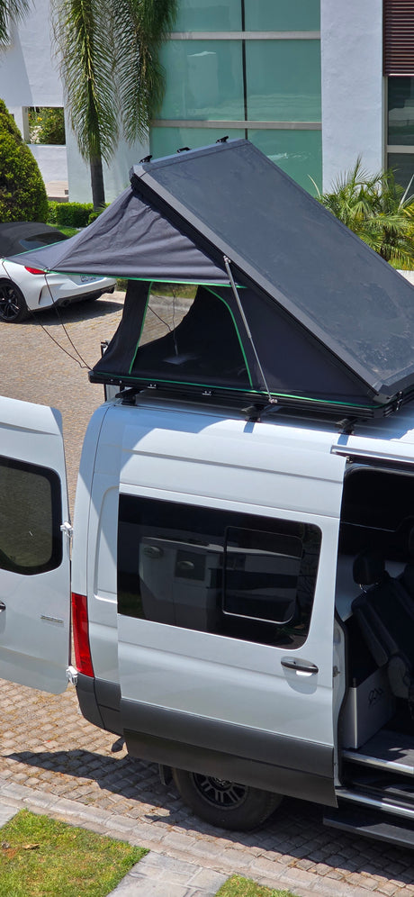 Explore with this rv rental! White camper van featuring an open rooftop tent and accessible interior.
