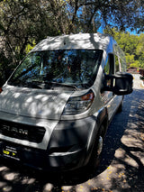White Ram ProMaster van, ideal for your next rv rental adventure, parked on a sunny, tree-lined path.