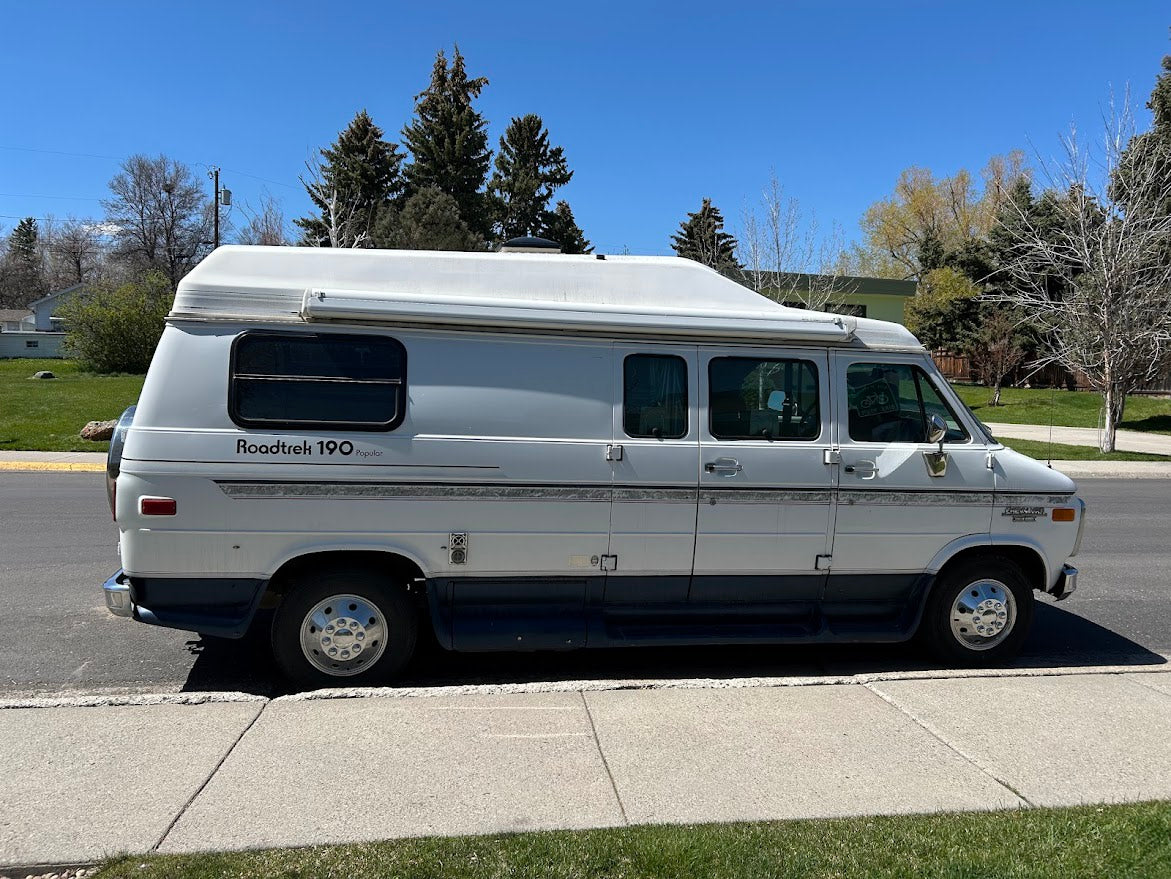 White Roadtrek 190 Popular camper van, ideal for an rv rental, parked on a sunny street.