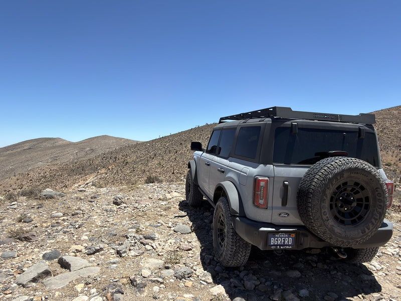  great for an rv rental exploring rocky off-road trails.|A grey Ford Bronco conquers a rugged desert trail under a clear sky. Your next adventure awaits — photo 7