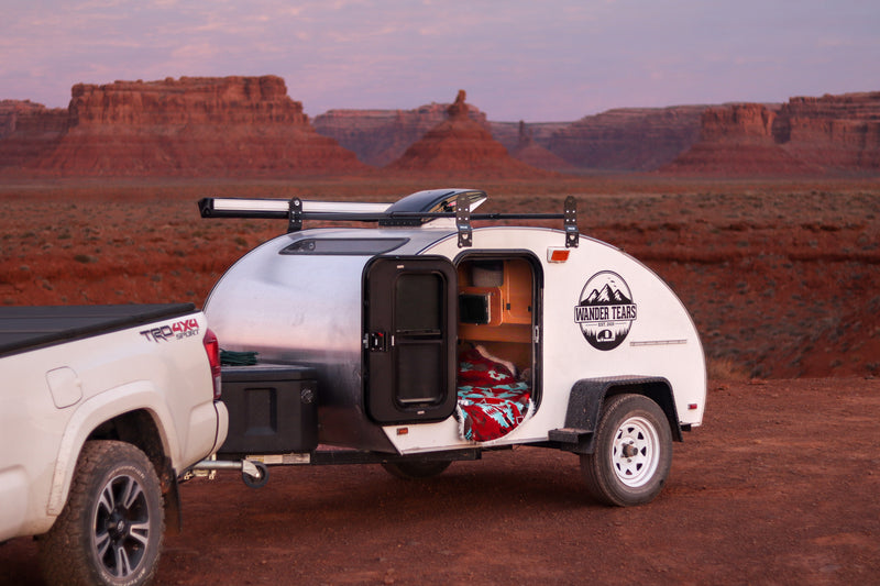 This RV rental teardrop camper, hitched to a truck, awaits desert camping adventures under a twilight sky. — photo 2