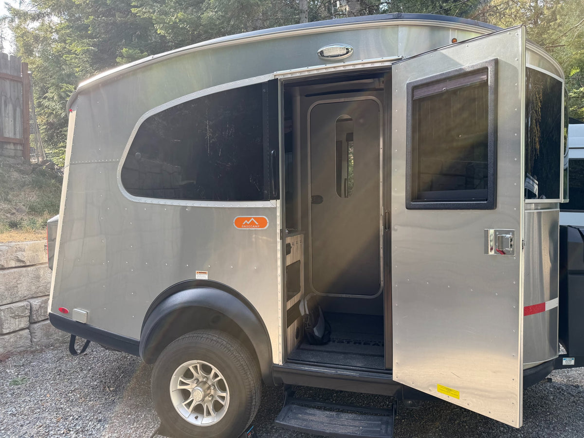 Airstream Basecamp rv rental: The silver travel trailer shows its open side door and steps