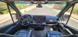 Spacious interior of an RV rental van showing the modern cockpit, driver's view, and the road ahead.