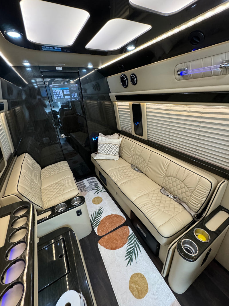 Spacious luxury RV rental interior with plush cream seating, modern controls, and ambient light for a comfortable journey. — photo 12
