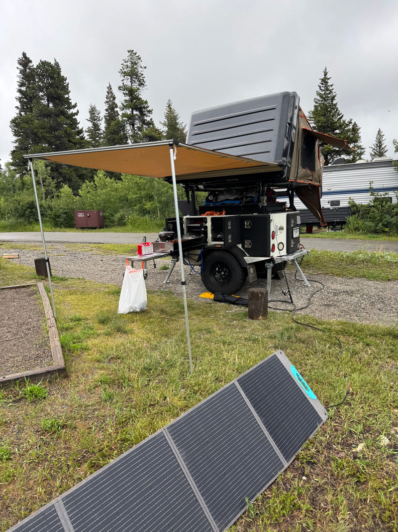 RV rental campsite setup: overland camper, awning, and portable solar panel for comfortable outdoor travel. — photo 8