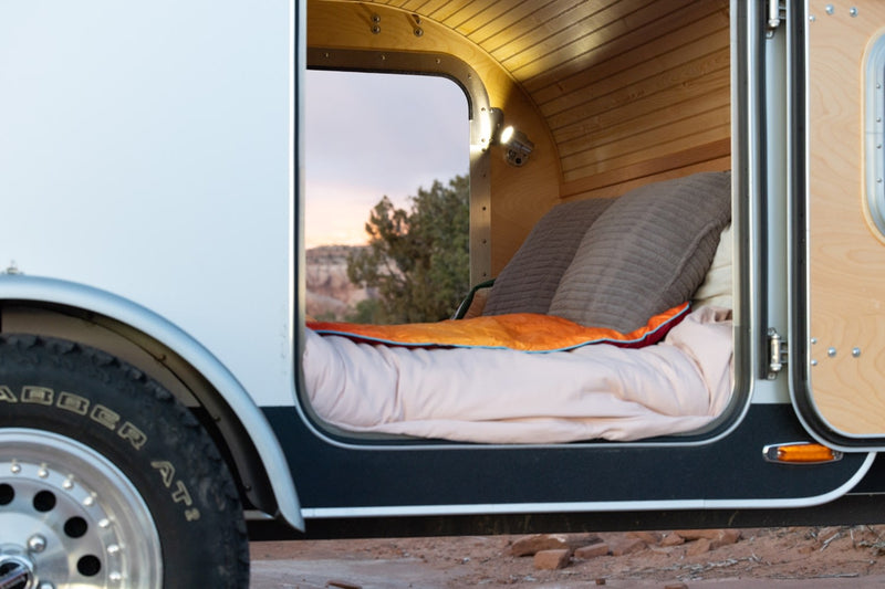  offering comfort & a scenic sunset view from inside the camper.|This teardrop RV rental offers a cozy bed and sunset views. Parked on leveling blocks — photo 11