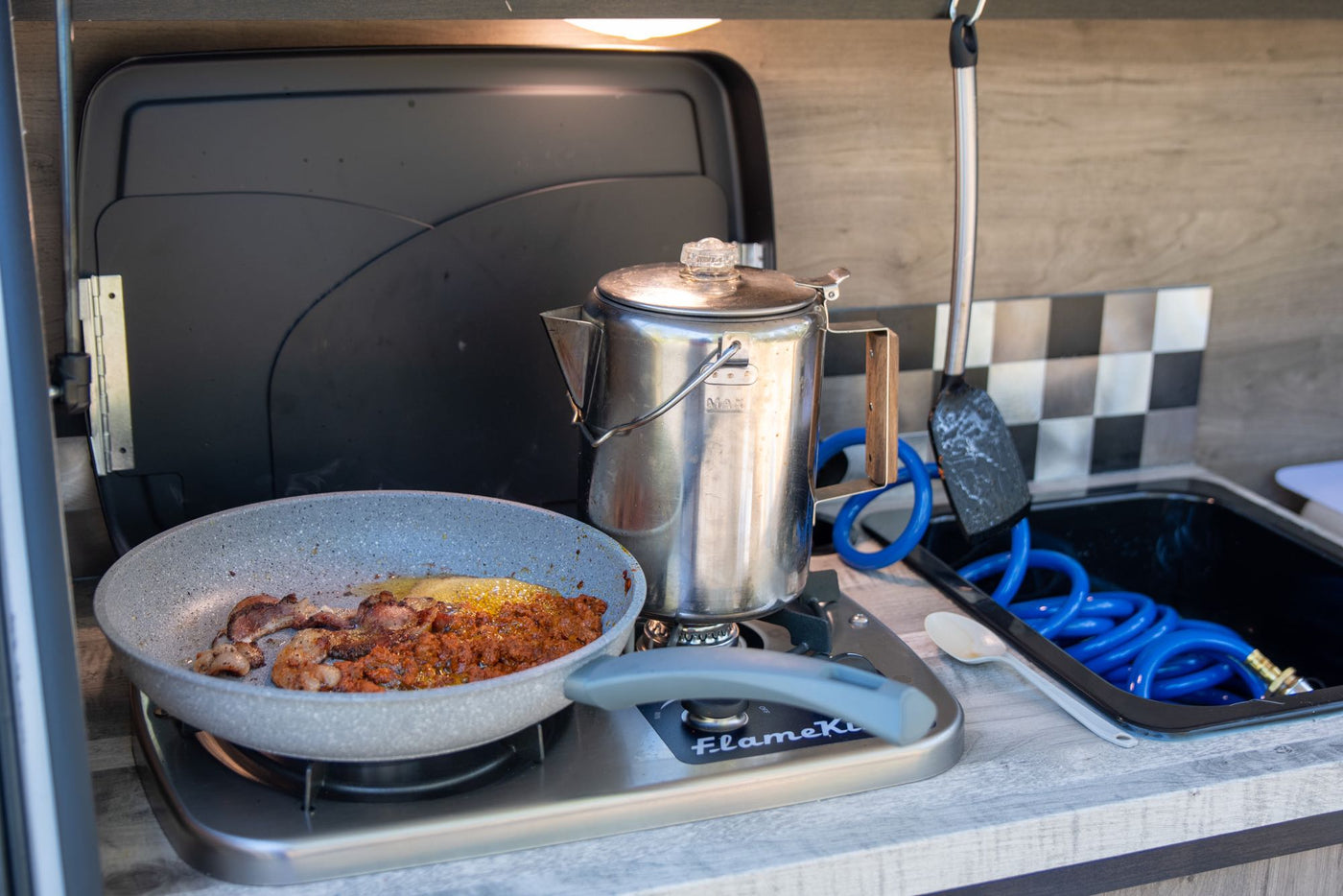 features an open rear kitchen & side awning for desert camping.|Detailed RV rental floor plan: Kitchen (cooktop — photo 4