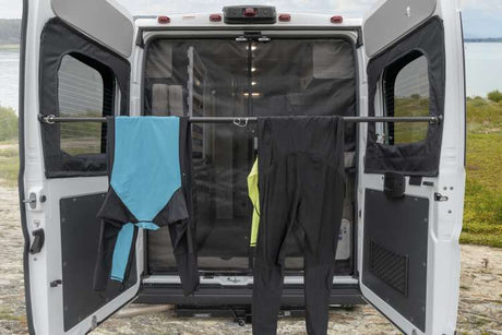 RV rental's rear doors open, featuring a drying bar for activewear. Ideal for adventurers to dry gear outdoors.