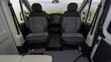 RV rental van's cockpit, showing front seats, dashboard, and a scenic water view. Fire extinguisher visible.