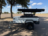 A white off-road camping trailer with a rooftop tent, perfect for an RV rental outdoor adventure.