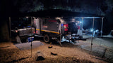 Nighttime setup of a Conqueror overland camping trailer, fully illuminated. Perfect for an RV rental adventure.