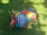 This vibrant "Equip One Person Travel Hammock" sits on sunny green grass, ready for an RV rental adventure.