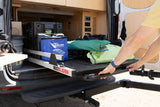 Man pulls out a BEDSLIDE from an RV rental van, showing organized storage for camping gear like Lynx Levelers.
