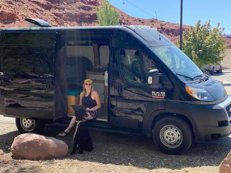  she sips coffee; the van reveals a cozy kitchen.|Black Ram ProMaster van — photo 2