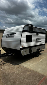White and grey Coleman travel trailer with black trim, ideal for your rv rental camping trip.