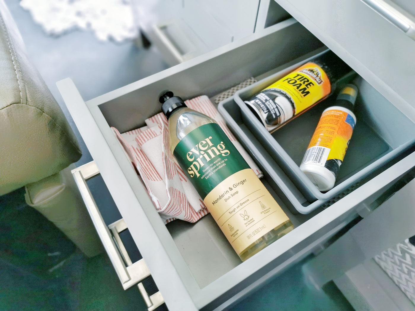 Stay organized in your rv rental! This drawer holds Ever Spring dish soap, a towel, and Armor All Tire Foam. — photo 5