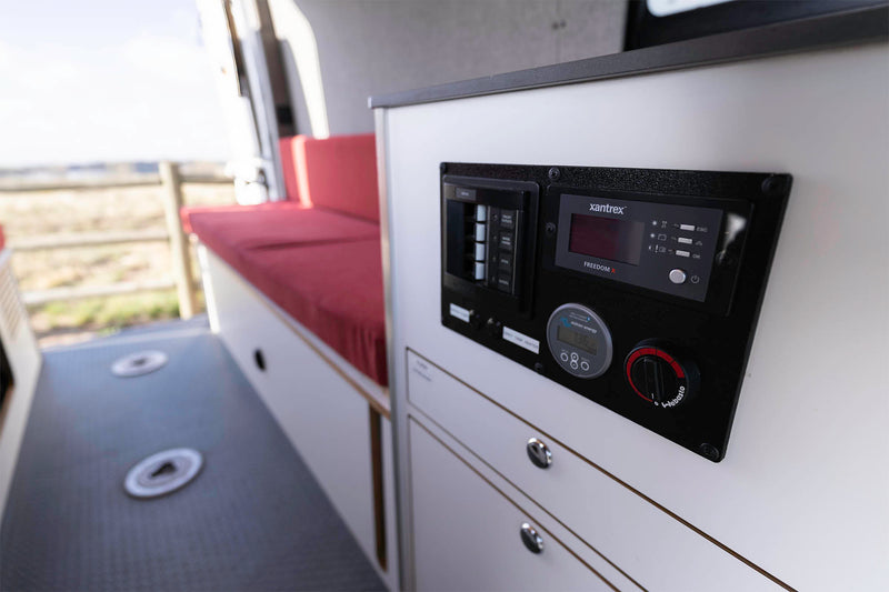 and ample storage for trips.|Inside your RV rental: a comfortable dining nook with a long white table and plush red bench seating.|RV rental interior with a cozy wood ceiling — photo 11