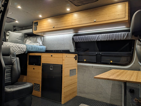 Experience comfort in this RV rental: bamboo kitchenette, microwave, fridge, and bed. Perfect for your road trips.