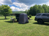 Outdoor adventure setup: SUV, camper with awning, and privacy tent. Perfect for an RV rental getaway!