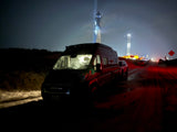 Night shot: An RV rental parked near the brightly lit SpaceX Starship launch tower at Boca Chica, Texas.