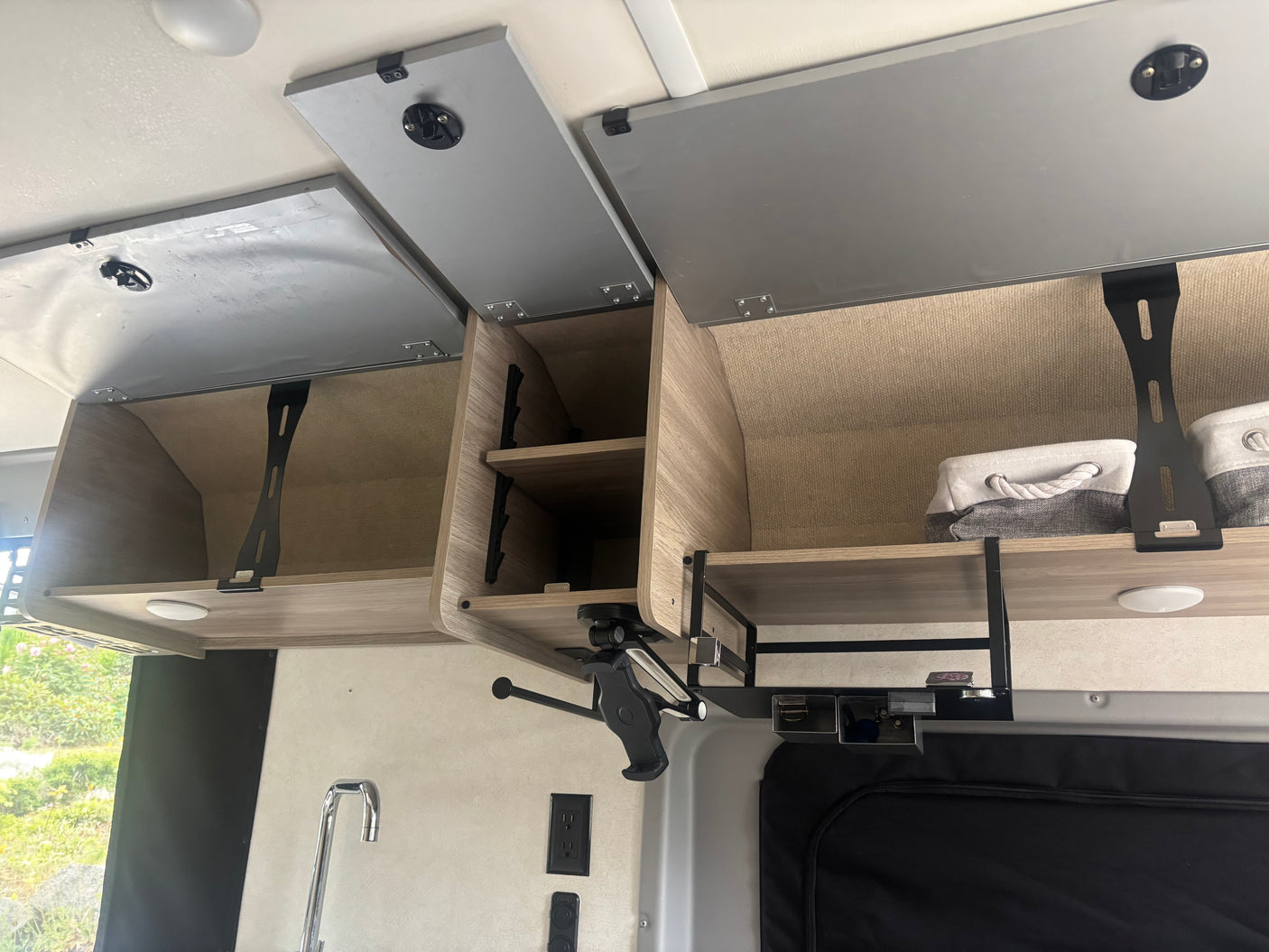 RV rental interior: overhead storage with open cabinets, shelves, and kitchen area details, highlighting space & organization.