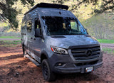 Gray Mercedes Sprinter van rv rental, an off-road camper, ready for Idaho adventures, parked on a dirt path.